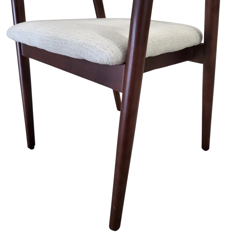 Détail de l’assise et des pieds de la chaise CARLYON en noyer massif avec tissu Marbella beige